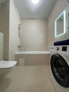 ein Badezimmer mit einer Waschmaschine und einer Badewanne in der Unterkunft Апартаменти м.Буча ЖК Гранд Бурже in Bucha