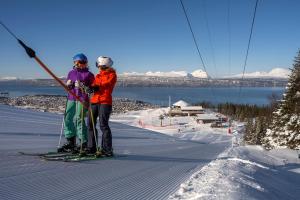 twee mensen op een skilift in de sneeuw bij Basecamp Narvik in Narvik