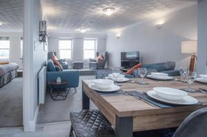 a living room with a dining table and a living room at North Beach Heights - 2 Bedroom Penthouse - Tenby in Tenby