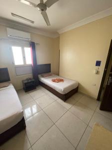 Zimmer mit 2 Betten und einem Fenster in der Unterkunft Makkah Hotel in Qinā