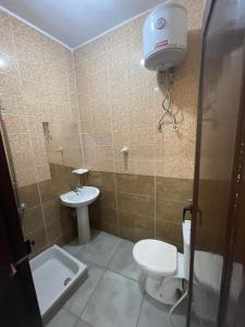 uma casa de banho com um WC e um lavatório em Makkah Hotel em Qinā