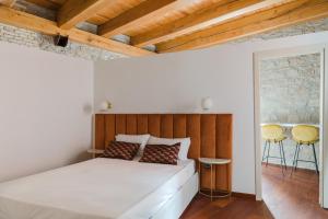 Schlafzimmer mit einem weißen Bett und Holzdecken in der Unterkunft Torre Capranica in Rom