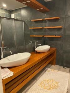 een badkamer met twee wastafels op een houten aanrecht bij TRABZON YALINCAK TERAS 1 SİTESİ in Trabzon