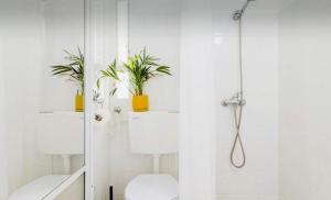 a bathroom with a toilet and a shower with two plants at Hollyday & vacation in Beit Hillel