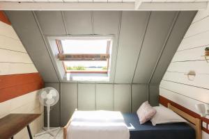 Habitación pequeña con cama y ventana en L'atelier en La Chapelle-Saint-Martin-en-Plaine