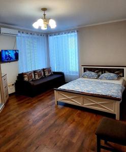 a bedroom with a bed and a couch in it at Апартаменти Буча ЖК Центральний in Bucha