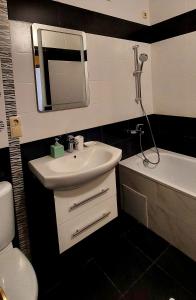 a bathroom with a sink and a toilet and a mirror at Апартаменти Буча ЖК Центральний in Bucha