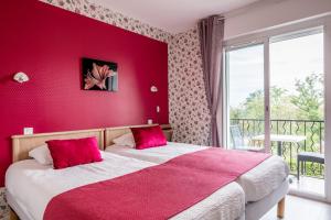 a bedroom with a red wall with a bed and a balcony at Aux Tauzins in Montfort-en-Chalosse