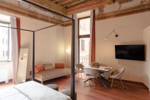 Un dormitorio con una cama, una mesa y un sofá. en Torre Capranica, en Roma