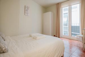 Cette chambre comprend un lit blanc et une grande fenêtre. dans l'établissement VALERIA-DREAMS Loscos, à Saragosse