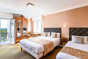 a hotel room with two beds and a balcony at Aux Tauzins in Montfort-en-Chalosse