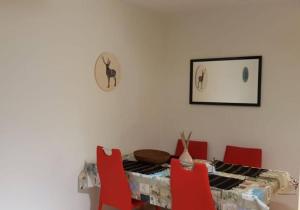 una sala da pranzo con tavolo e sedie rosse di 2.5 Rooms Furnished Family Apartment in Luzern-44 a Lucerna