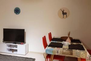 een woonkamer met een tafel en een televisie bij 2.5 Rooms Furnished Family Apartment in Luzern-44 in Luzern