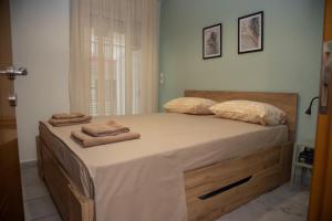 a bedroom with a large bed with towels on it at Fobillo Apartment at Charilaou in Thessaloniki
