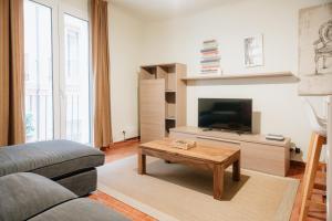 uma sala de estar com um sofá e uma televisão em VALERIA-DREAMS Loscos em Zaragoza