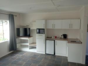 a white kitchen with white cabinets and appliances at Garden Court in Queenstown