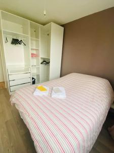- une chambre avec un lit et 2 serviettes dans l'établissement Superbe appartement à 10min du centre de Lyon, à Villeurbanne