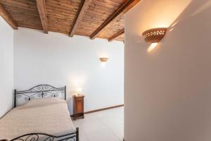 Un dormitorio con una cama y un techo de madera. en MariGiò Rooms, en Alliste