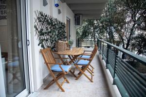 a porch with a table and chairs on a balcony at Fobillo Apartment at Charilaou in Thessaloniki