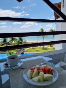 een fruitschaal op een tafel met een kopje koffie bij Maui Beach Residence, 3 quartos, Tamandaré PE in Tamandaré