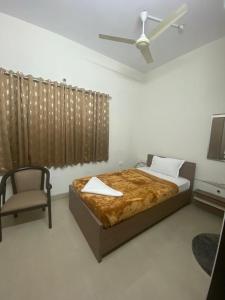 薩姆沙巴德的住宿－SHLOKA RESIDENCY，一间卧室配有一张大床和一把椅子