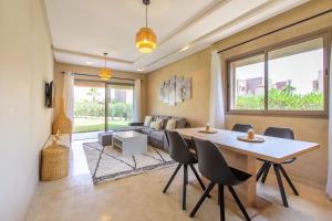 sala de estar con mesa, sillas y sofá en Appartement Pied dans l'Eau - jardin privée en Marrakech
