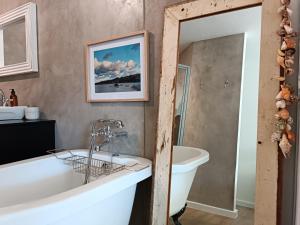 a bathroom with a tub and a sink at Lagoon Terrace 14 in Plettenberg Bay