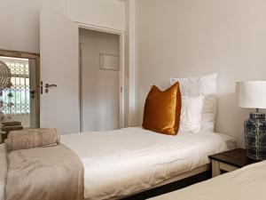 um quarto com uma cama com uma almofada amarela em Lagoon Terrace 14 em Plettenberg Bay
