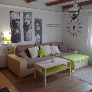 uma sala de estar com um sofá e um relógio na parede em Parányi Porta Bakonybél em Bakonybél