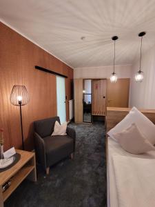 um quarto de hotel com uma cama e uma cadeira em Hotel Pieper-Kersten em Bad Laer