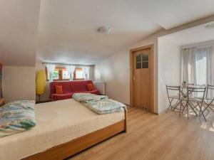 Un dormitorio con una cama y un sofá rojo. en Bobcikowa Chata, en Szczawnica