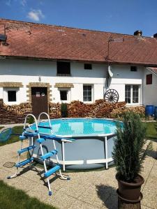 een zwembad met een tafel voor een huis bij Chalupa u dědy in Dlažkovice