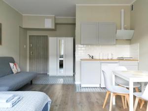 cocina y sala de estar con sofá y mesa en Apartamenty Świętojańska Gdynia Centrum, en Gdynia