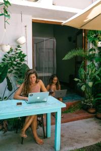 two women sitting at a table with a laptop at Mellow Hostel Sri Lanka in Ahangama