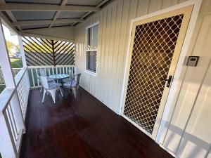 a screened in porch with a table and chairs at Charming 3 bedroom Workers Accommodation in Grafton