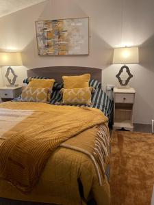 Dollar的住宿－Ravenwood Lodge，一间卧室配有一张带黄色毯子和枕头的床