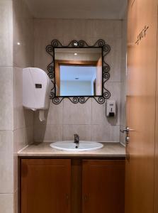 W łazience znajduje się umywalka i lustro. w obiekcie The Poets Inn w Porto