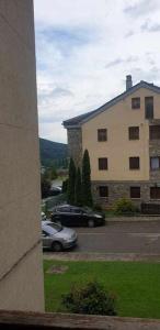 un coche aparcado en un aparcamiento al lado de un edificio en Acogedor apartamento en el Pirineo aragonés, en Villanúa