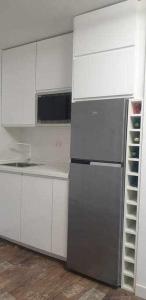 a kitchen with a refrigerator and white cabinets at Acogedor apartamento en el Pirineo aragonés in Villanúa