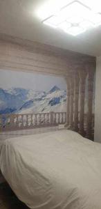 1 dormitorio con 1 cama con un mural de montaña en la pared en Acogedor apartamento en el Pirineo aragonés, en Villanúa