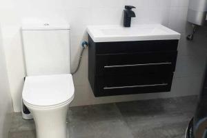 a bathroom with a white toilet and a sink at Acogedor apartamento en el Pirineo aragonés in Villanúa