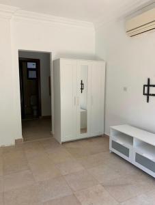 a room with a white cabinet with a cross on it at Ground Floor Room with Garden in Sheikh Zayed
