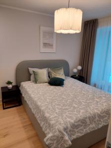 a bedroom with a large bed with a gray headboard at Albatross Apartment Romantic in Ķesterciems