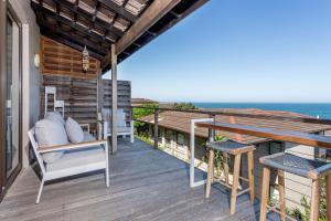 a deck with a table and chairs and the ocean at 8 Sovereign Sands Sea Views, Blythdale in KwaDukuza