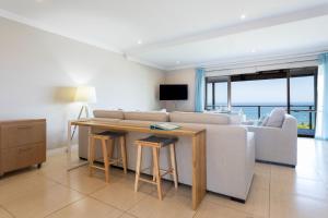 ein Wohnzimmer mit einem Sofa und einem Tisch in der Unterkunft 8 Sovereign Sands Sea Views, Blythdale in KwaDukuza