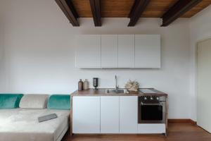 una cocina con armarios blancos y un sofá en una habitación en Torre Capranica, en Roma