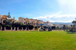 a park with a playground and buildings in the background at Zahara almadraba playa Atlanterra in Zahara de los Atunes