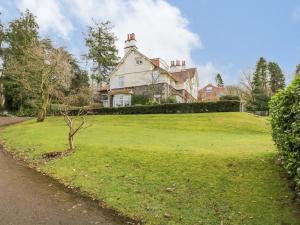 uma casa grande numa colina relvada com uma árvore em Lake House Loft em Windermere