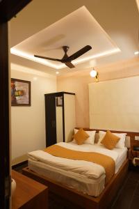 a bedroom with a bed with a ceiling fan at The Royal Hotel in Haldwāni