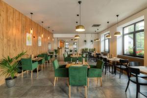 a dining room with tables and green chairs at Hotel Lípa in Dolní Lipová